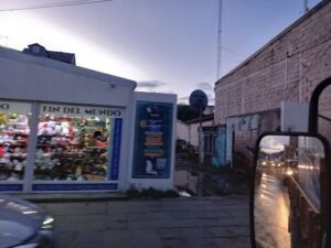 A view of a street corner with a storefront and a car.