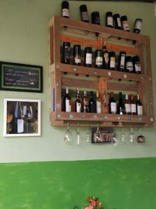 A wine rack with a variety of wine bottles and glasses.
