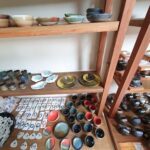 A wooden shelf filled with various bowls and plates.