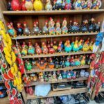 A wooden shelf filled with various chicken figurines.
