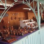 A wooden table filled with various items, including vases, bowls, and knives.